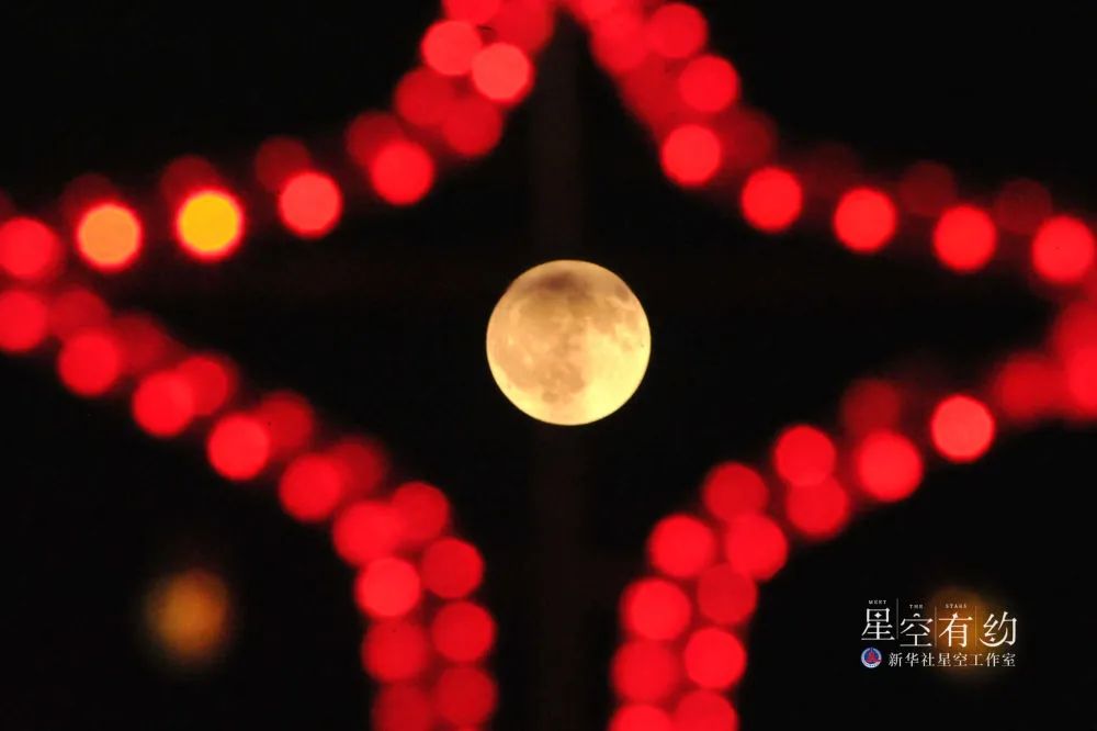 这是2013年2月26日凌晨在山西省运城市新绛县拍摄的圆月和彩灯。（新华社发）