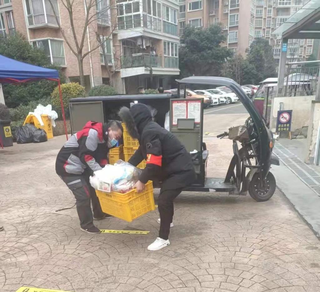 邓永金（左）在帮忙搬运生活物资。（受访者供图）