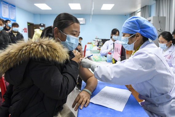 1月18日，生活在广西兴业县“老乡家园”的群众在小区对面的医院里接种新冠疫苗。新华社记者 曹祎铭 摄