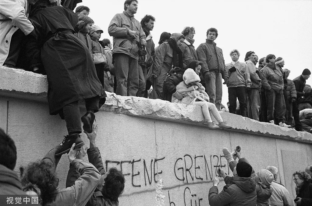 资料图：1989年12月31日，东柏林人爬上柏林墙庆祝柏林墙的时代将要终结。