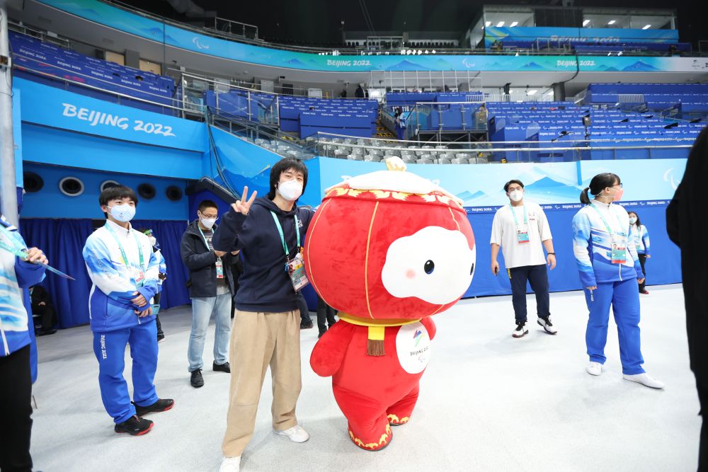 在残奥冰球金牌赛后,新华社见习记者胡星宇在国家体育馆与雪容融合影
