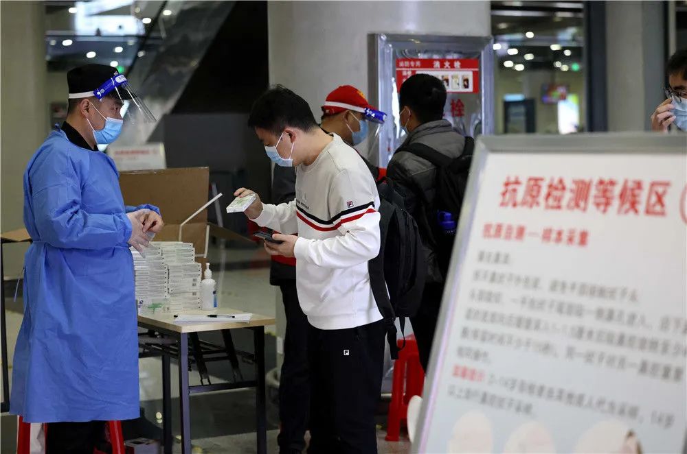 3月27日,在合肥火车站出站大厅,出站旅客领取免费发放的抗原检测试剂。新华社发(解琛 摄)