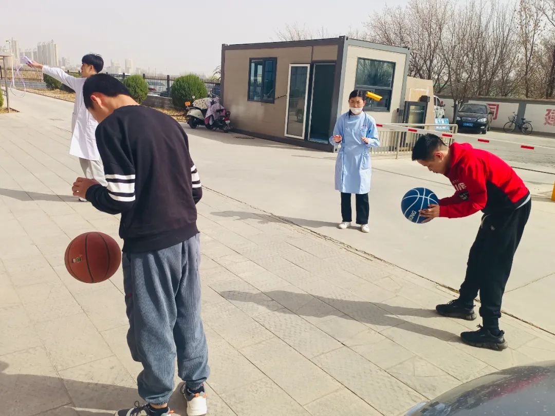 宁夏银川一家残疾人托养服务中心内,几名残疾人在护理人员陪同下学习打篮球 冷瑞洁/摄