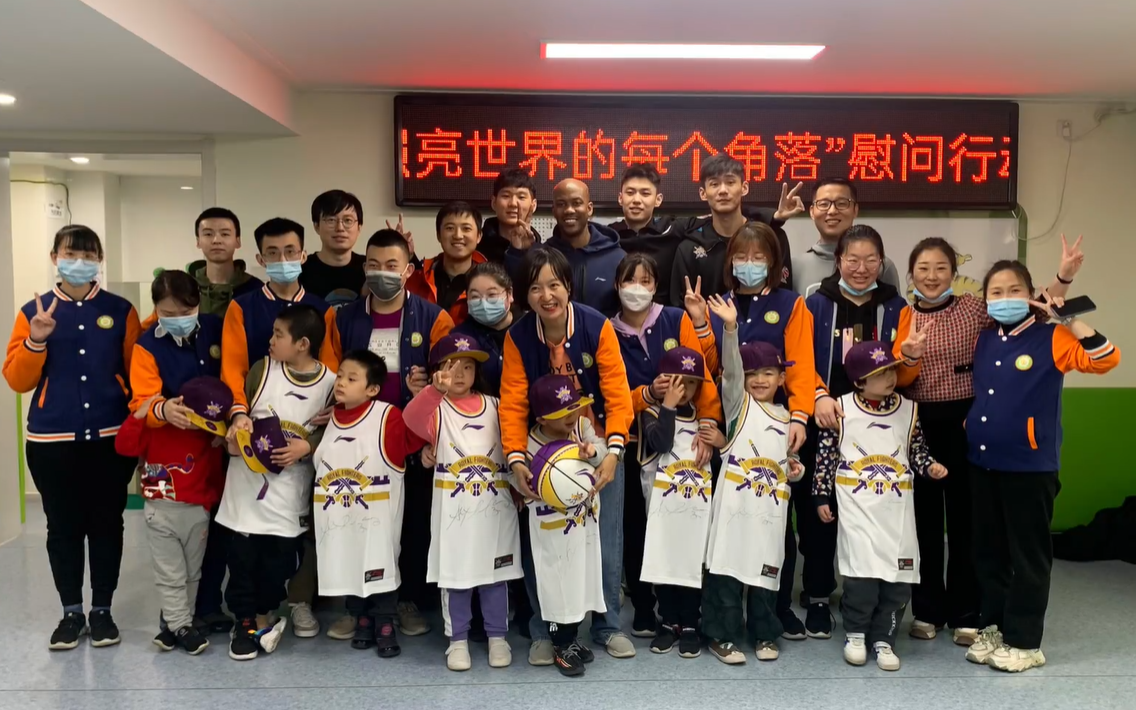 马布里携队员与自闭症儿童合影。北京控股篮球俱乐部微博视频截图
