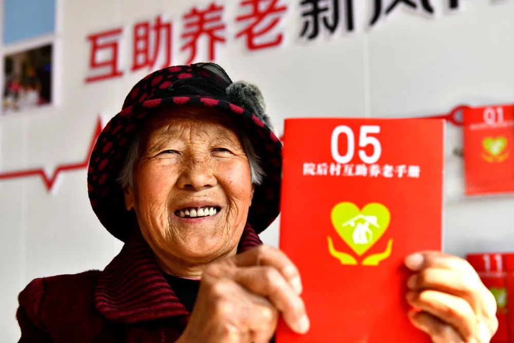  2022年3月4日，在山东乳山市南黄镇院后村暖心食堂，一位老人展示自己的互助养老手册。 新华社记者 郭绪雷 摄
