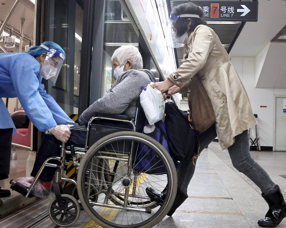 4月26日，地铁工作人员帮助从医院看病返回的市民上车。
