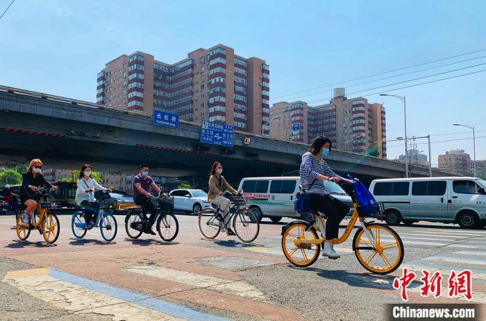 5日，北京东三环附近正骑单车出行的市民。 共享单车企业供图。