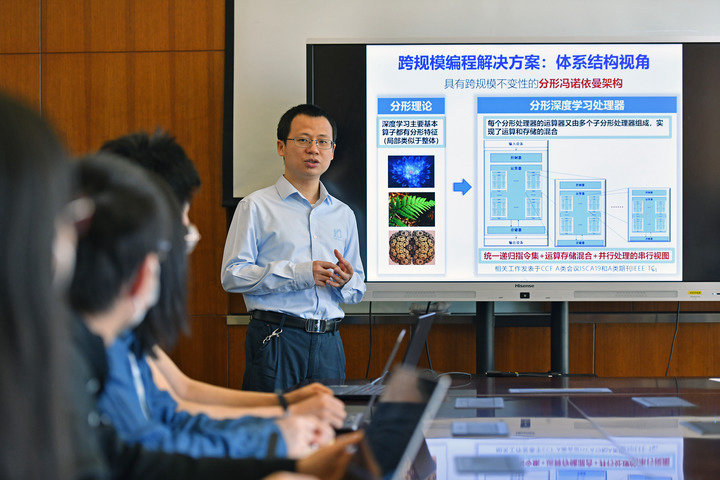 陈云霁（右一）与科研团队成员讨论设计方案。新华社记者李鑫摄
