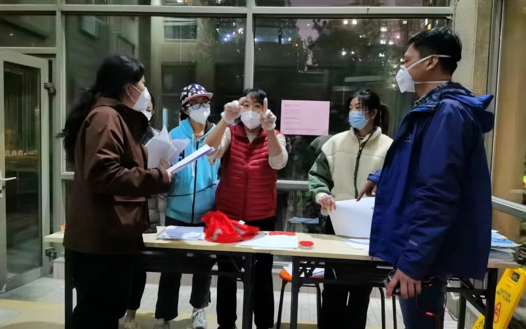 ▲核酸检测开始前一天，张松涛（右一）和团队工作人员在做准备工作。受访者供图