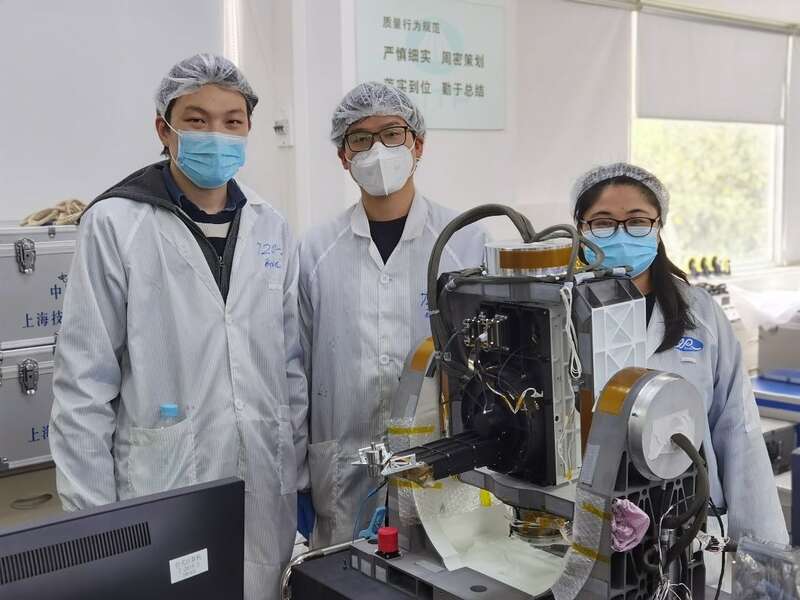 江丰（左一）和同事坚守在实验室开展调试