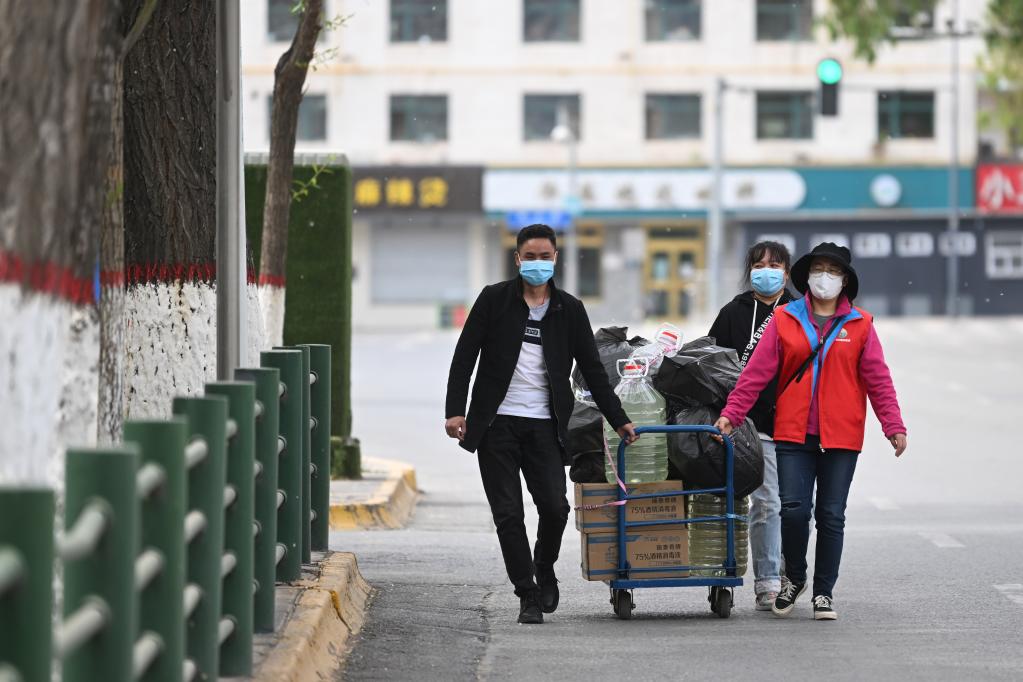 5月10日,在青海省西宁市城中区南山东社区，社区工作人员在运送防疫物资。（新华社记者 张龙 摄）