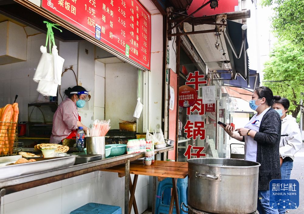 在上海市嘉定区新成路街道，居民在一家蛋饼店前排队（5月9日摄）。