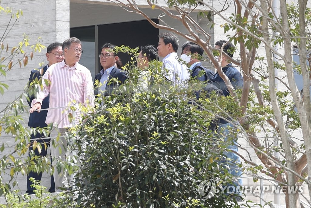 当地时间5月11日，文在寅在私宅前与前政府官员交谈 图源：韩联社
