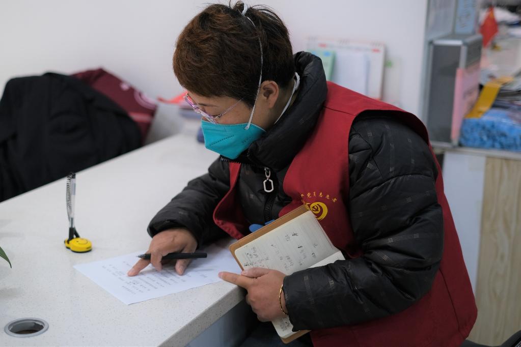 5月13日,张梅在西宁市城西区海晏路社区综合服务中心核对志愿者信息。(新华社记者 童昊 摄)