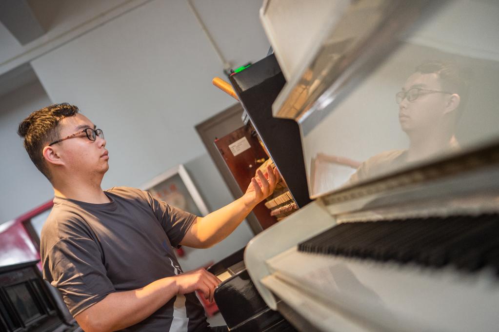 工人在修复技术中心对古董钢琴进行调音处理。新华社记者 伍志尊 摄