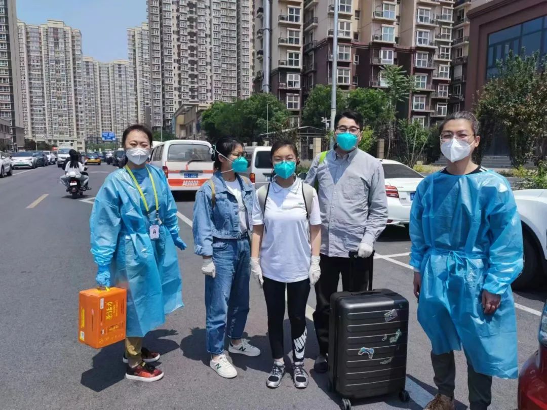 ▲5月20日中午,沈婷(左三)和父母返回小区后,与社区工作人员合影。 受访者供图
