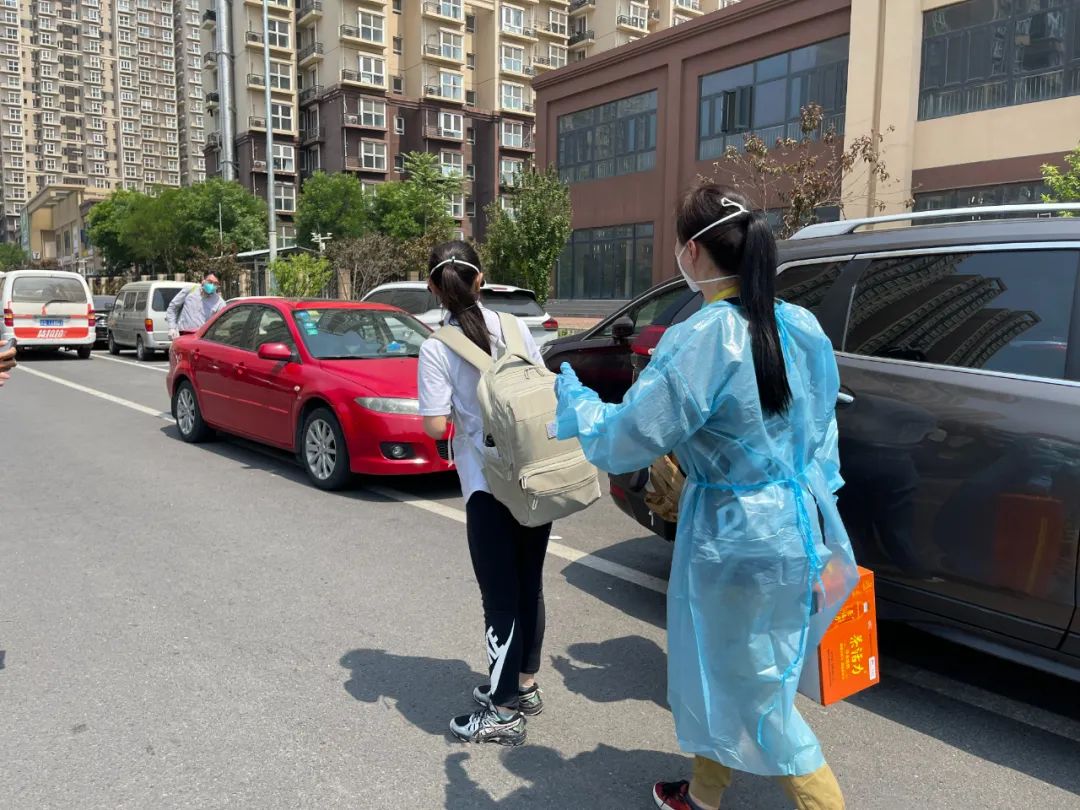 ▲5月20日中午,沈婷(前)在社区工作人员李夕子的陪伴下回家。 受访者供图