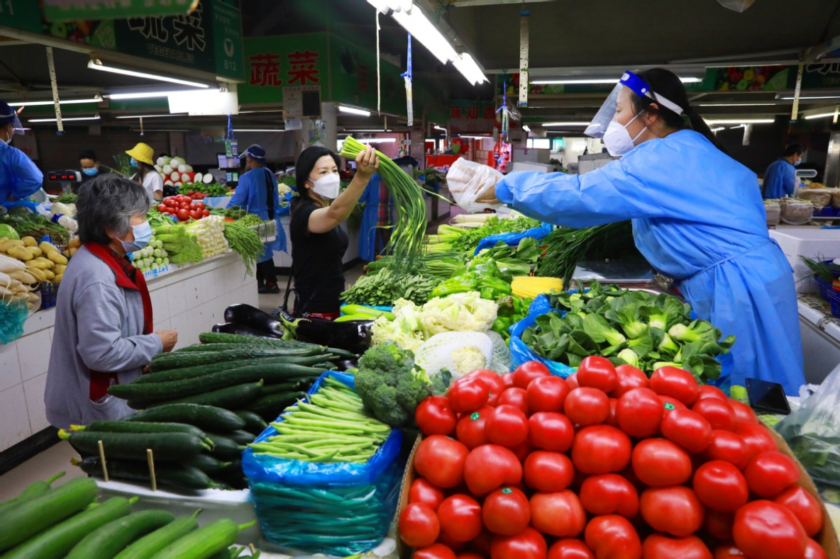 上海市嘉定区农贸市场居民在购买新鲜蔬菜。 中国日报记者朱兴鑫/摄