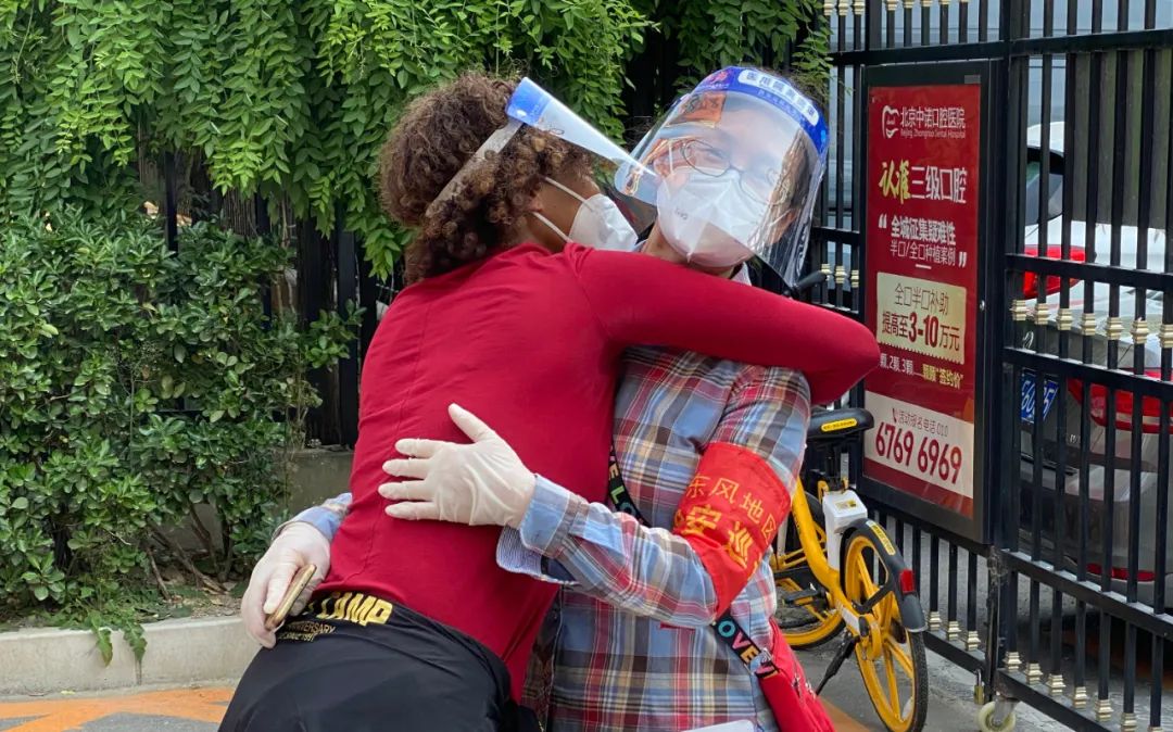 ▲志愿服务结束后，玛丽亚与其他志愿者拥抱。新京报实习生 秦巍峰 摄