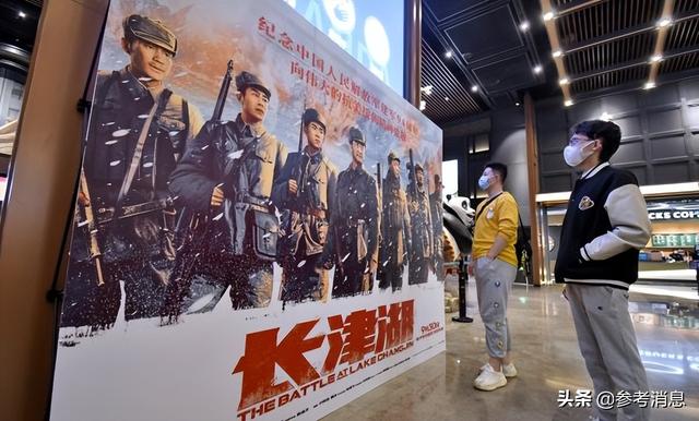 两名年轻人在北京一家影院观看电影《长津湖》的海报(新华社发)