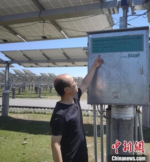 图为工作人员正在介绍光伏扶贫电站专用计量箱。 李洋 摄
