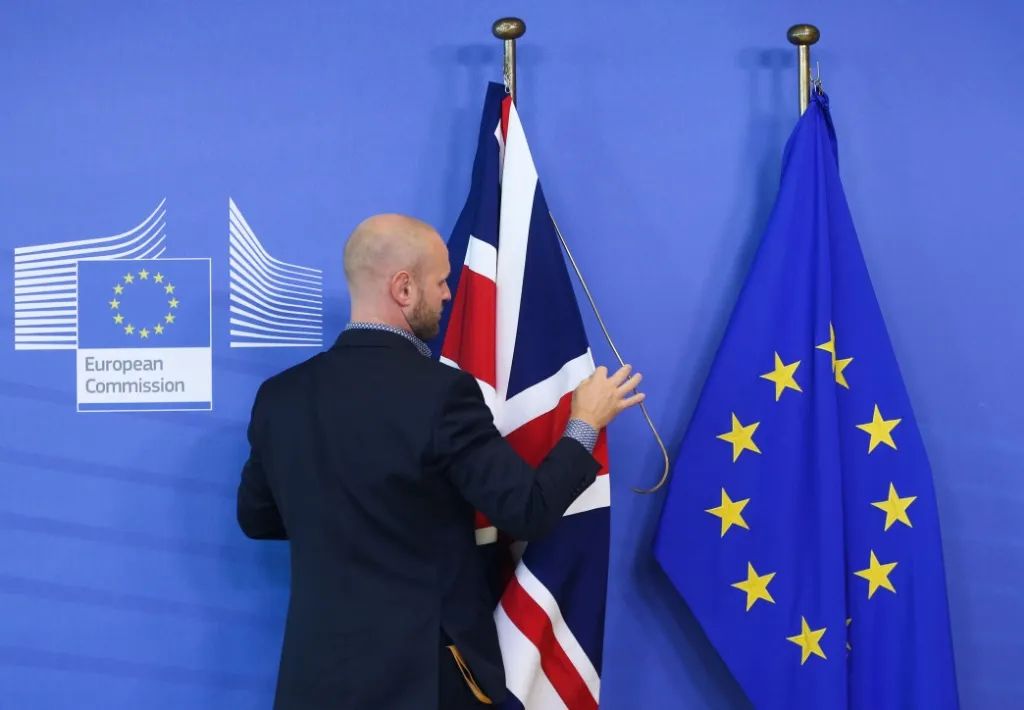 ▲2019年10月17日，在比利时布鲁塞尔的欧盟总部，工作人员整理英国和欧盟的旗帜。新华社记者郑焕松摄