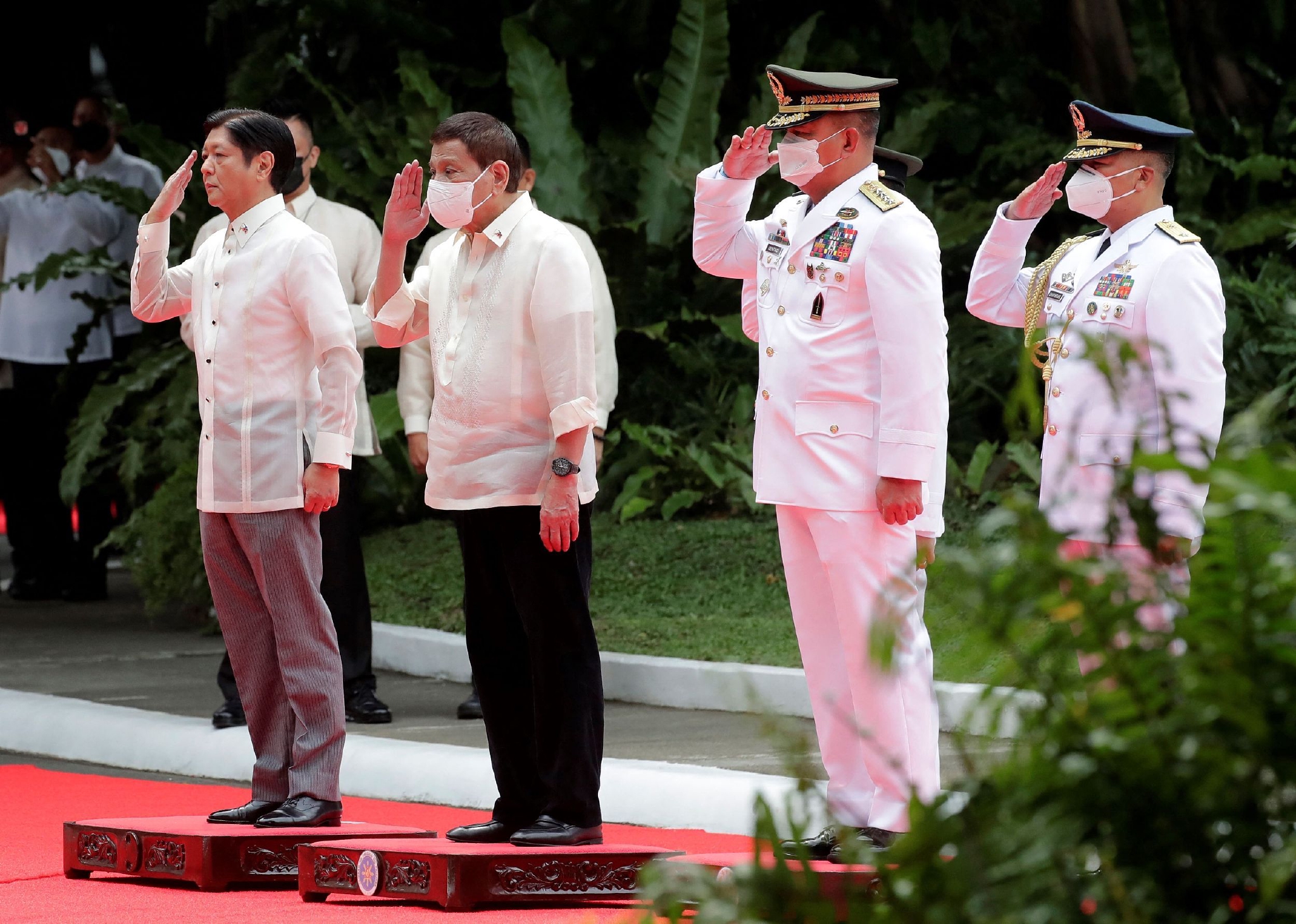 当地时间2022年6月30日，菲律宾首都马尼拉，马科斯（左一）与前总统杜特尔特（左二）在就职典礼上敬礼。视觉中国 图