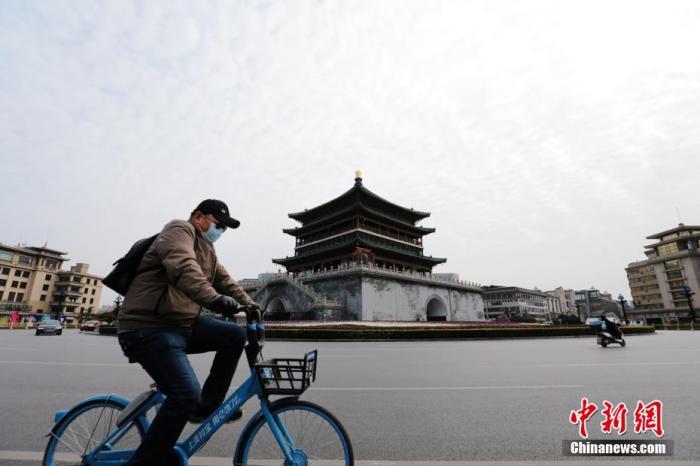 资料图:图为一位市民从西安钟楼前骑过。张远 摄