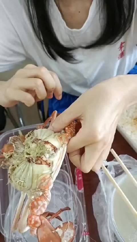 7月30日，广西北海。村民志愿者给大白医护讲解如果吃螃蟹🦀……