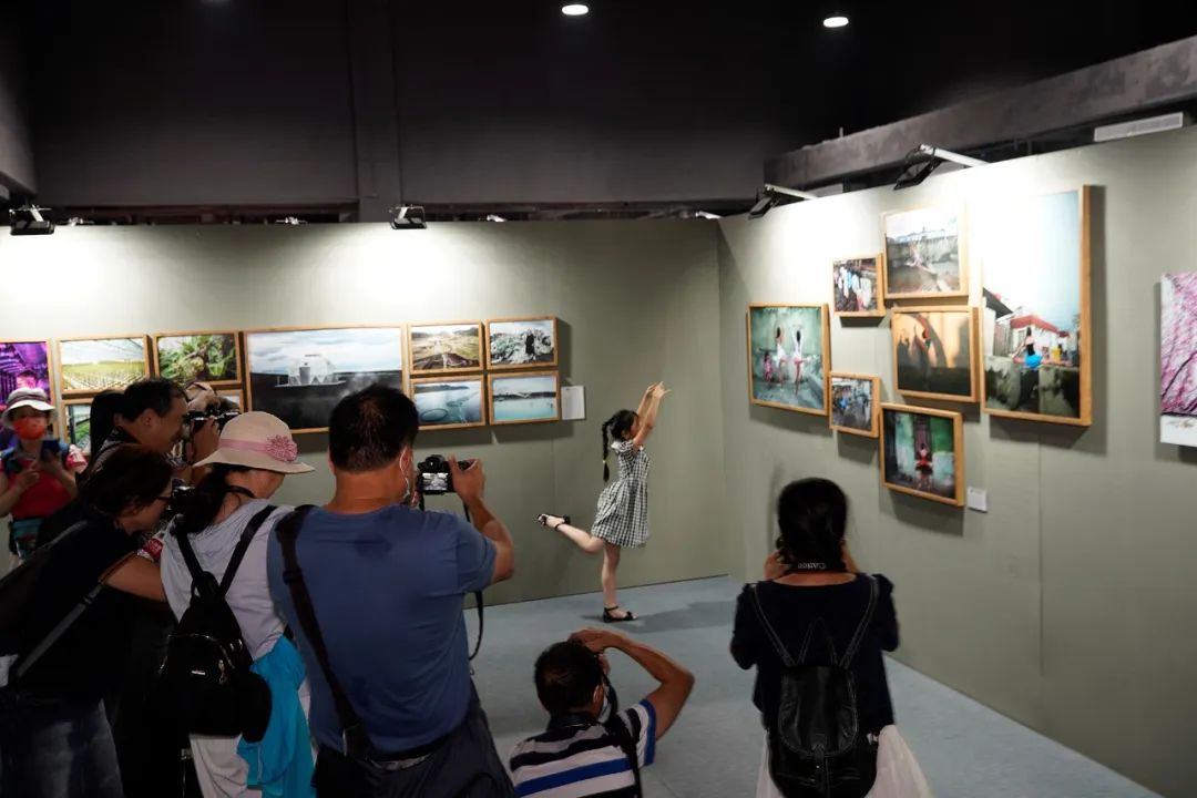 小观众在“无主题纪实类”展墙前与作品合影。陈黎明 摄