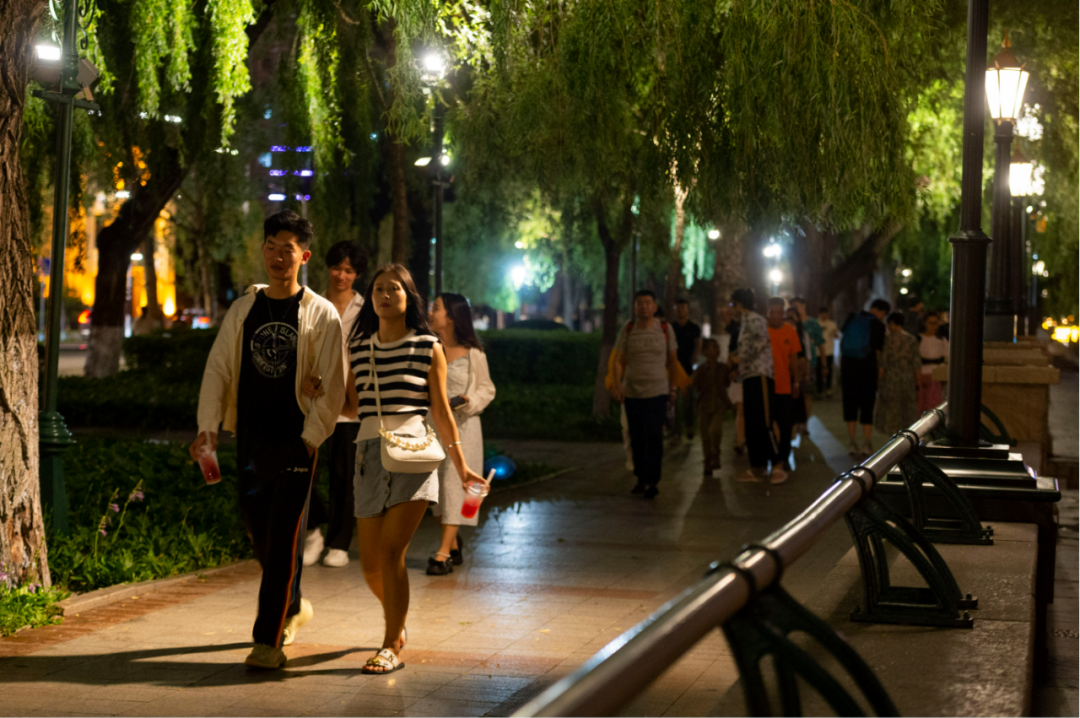 ▲7月14日,夏日夜晚,松花江哈尔滨段江畔景色优美,游人络绎不绝。图/新华社