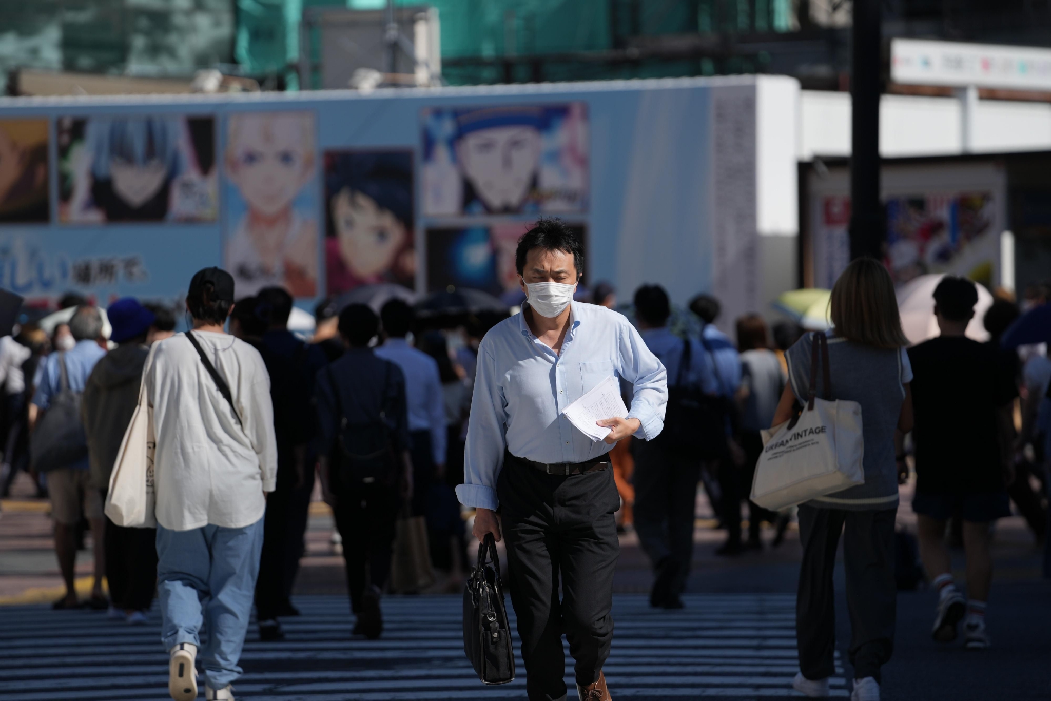 ▲7月29日，戴口罩的行人走在日本东京涩谷街头。图/新华社