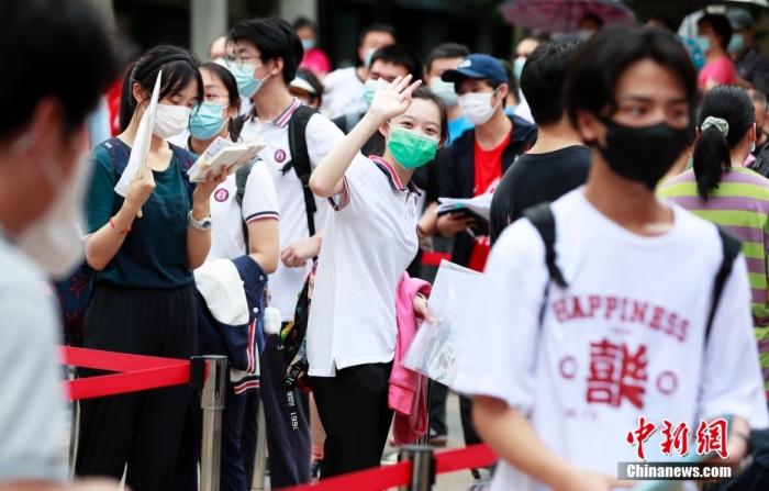 资料图:今年7月上海一名考生在进入考场前向家长挥手致意 中新社记者 汤彦俊摄