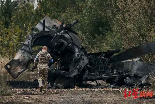 ↑一名乌军士兵路过被摧毁的俄军坦克