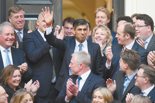 24日，英国保守党成员在总部外迎接新党首苏纳克（中）。
