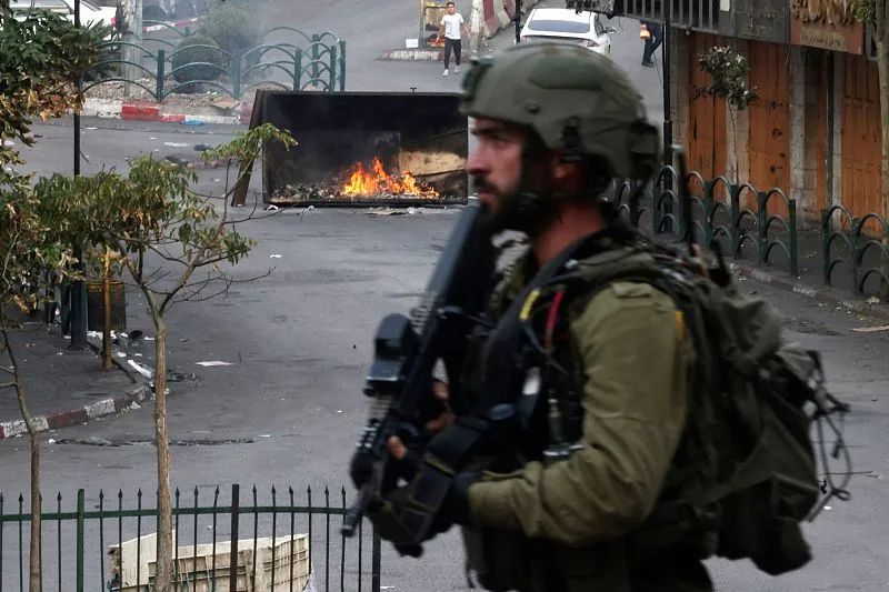 当地时间10月30日，约旦河西岸希伯伦，以色列安全部队在与巴勒斯坦抗议者的冲突中展开部署。图源：视觉中国