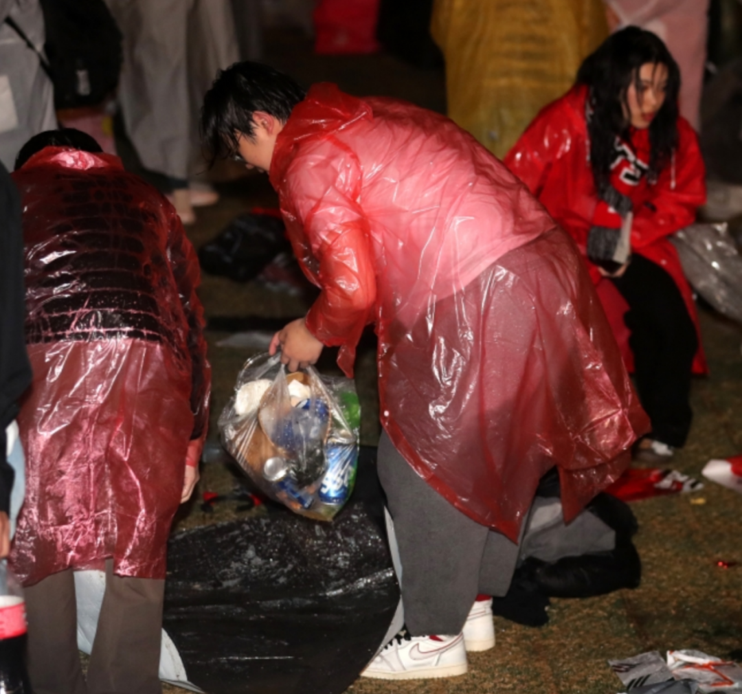 28日晚，街头助威活动结束后，部分韩国民众留在现场，清理被随手丢弃的垃圾。图自韩媒