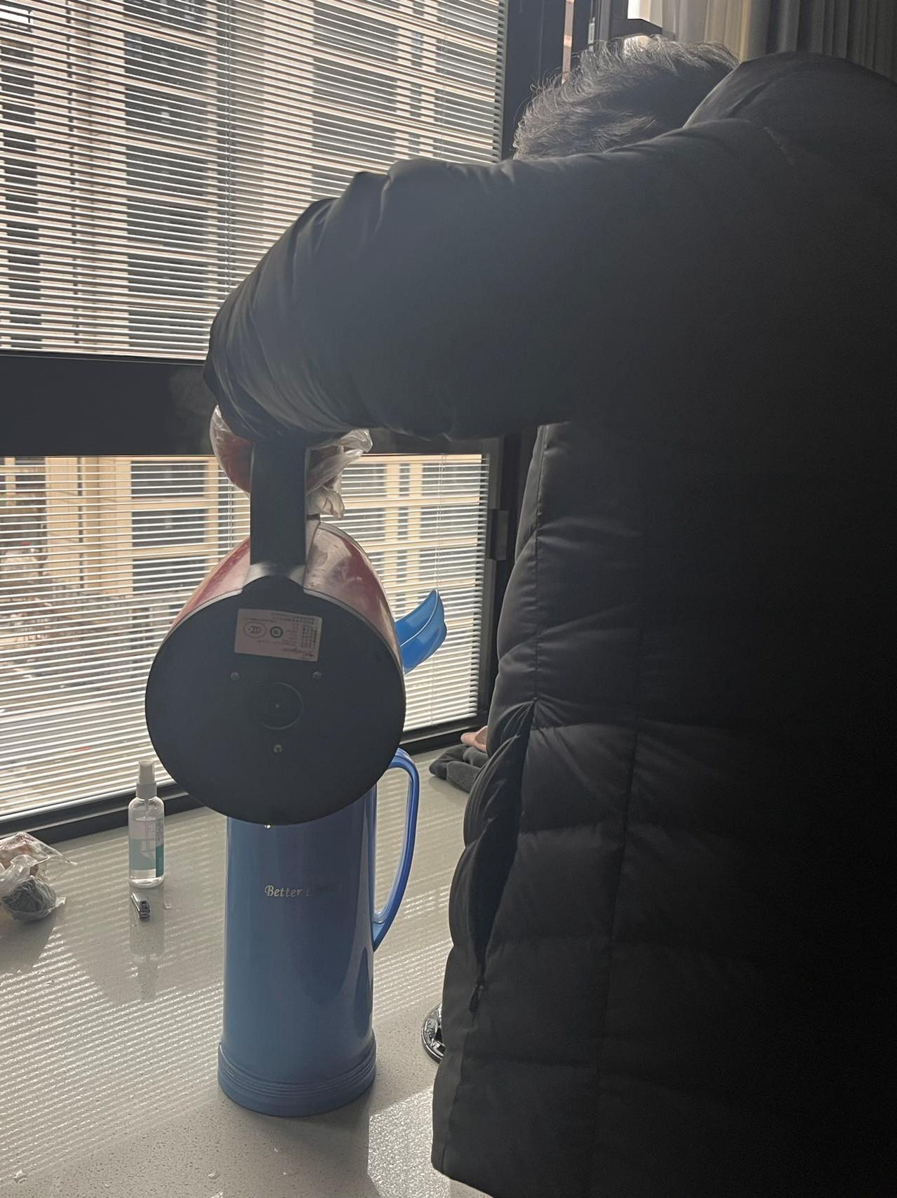 母亲戴着手套,给我的热水瓶加水。