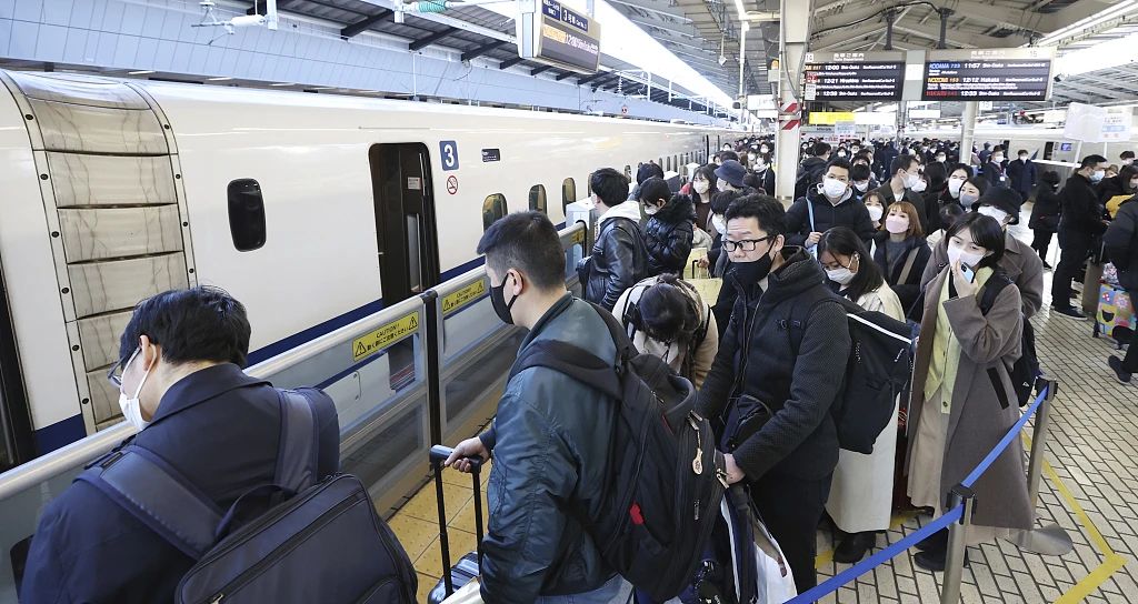 ��地�r�g2022年12月29日，日本�|京站，�y�Т蠹�行李的乘客在新干�高�F站�_上。�D/��X中��