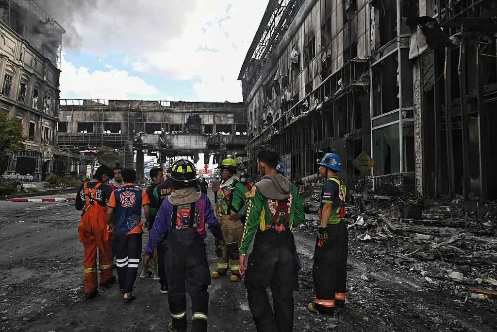▲当地时间2022年12月29日，柬埔寨波贝，波贝发生大火后，消防员站在钻石城大酒店被烧毁的建筑物中。图/视觉中国