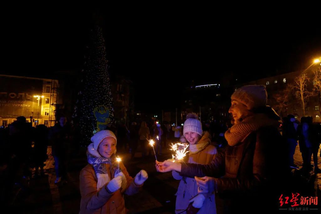 在昏暗的灯光中，不少乌克兰人聚集在广场点燃了烟花