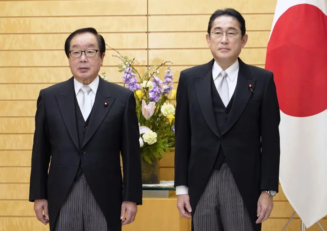 当地时间2022年12月27日，日本东京，日本新任复兴大臣渡边博道（左）和首相岸田文雄在皇宫与德仁天皇参加了认证仪式后，在首相办公室合影留念。图/视觉中国