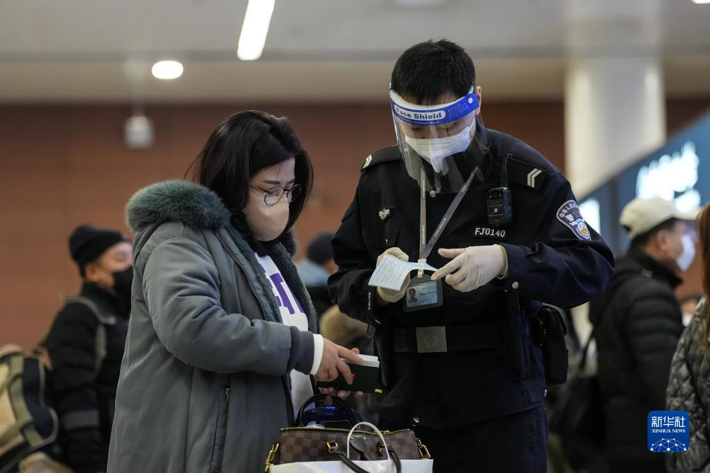 1月24日,沈阳出入境边防检查站民警帮助旅客通关。来源:新华社