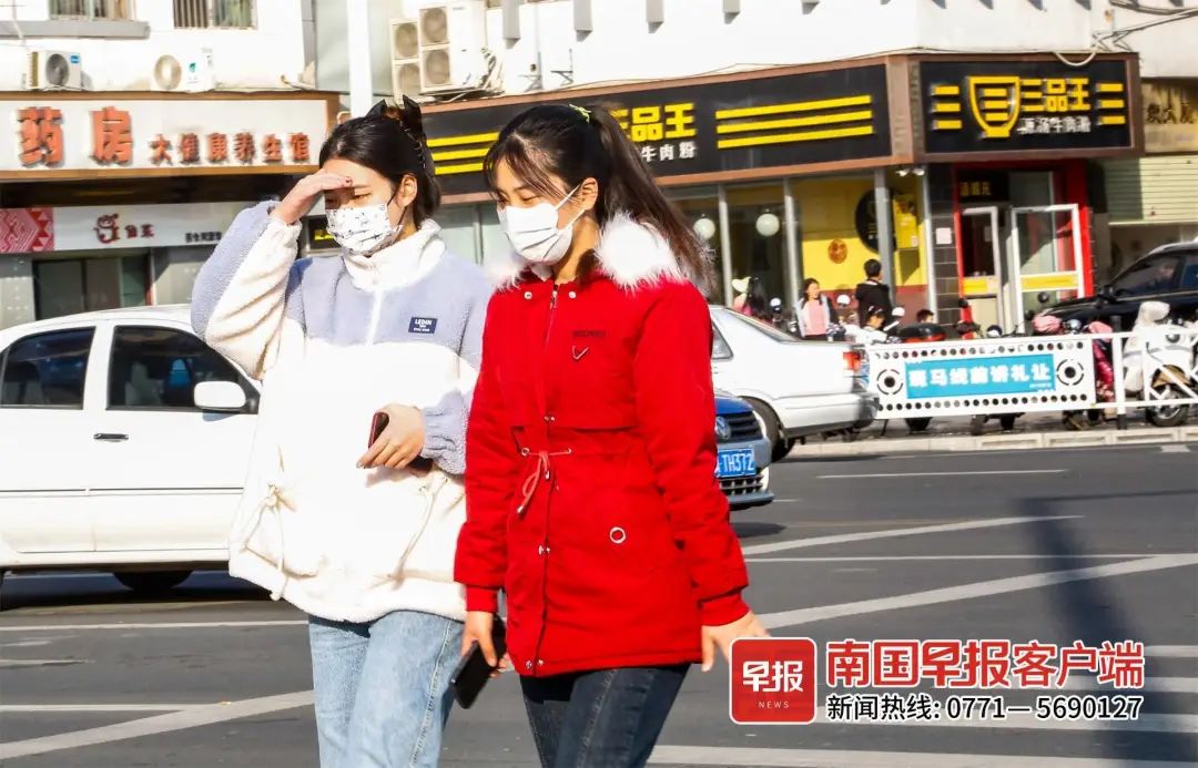 ▲1月28日,南宁市民族大道古城路口,穿着厚衣服的市民用手遮挡阳光。南国早报记者 游拥军摄