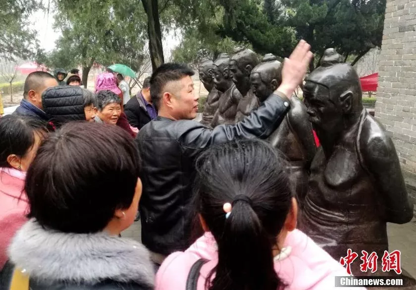 图为河南淮阳游客岳飞观里冒雨“打秦桧”。中新网资料图。