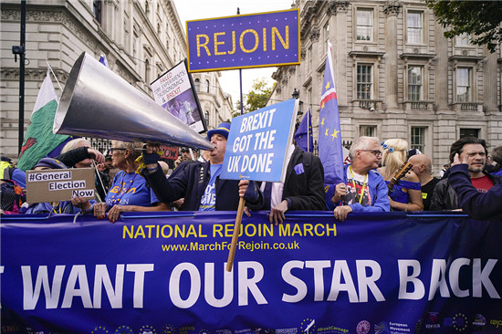 2022年10月22日，英国伦敦，示威者举着标语牌和旗帜在唐宁街聚集，要求英国重新加入欧盟。