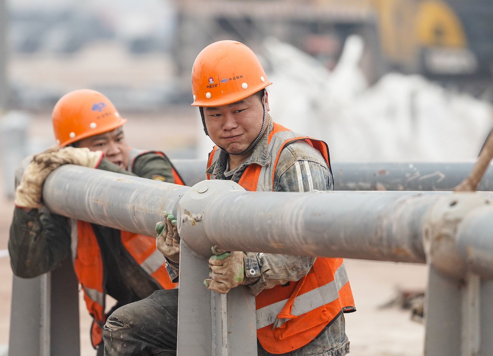 1月23日,在重慶兩江新區新能源汽車產業園基礎設施配套項目現場,工人在進行鋼結構材料拼裝作業。