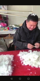 ▲近日,耒阳,陈先生在挑选做羽绒服的绒朵。 视频截图