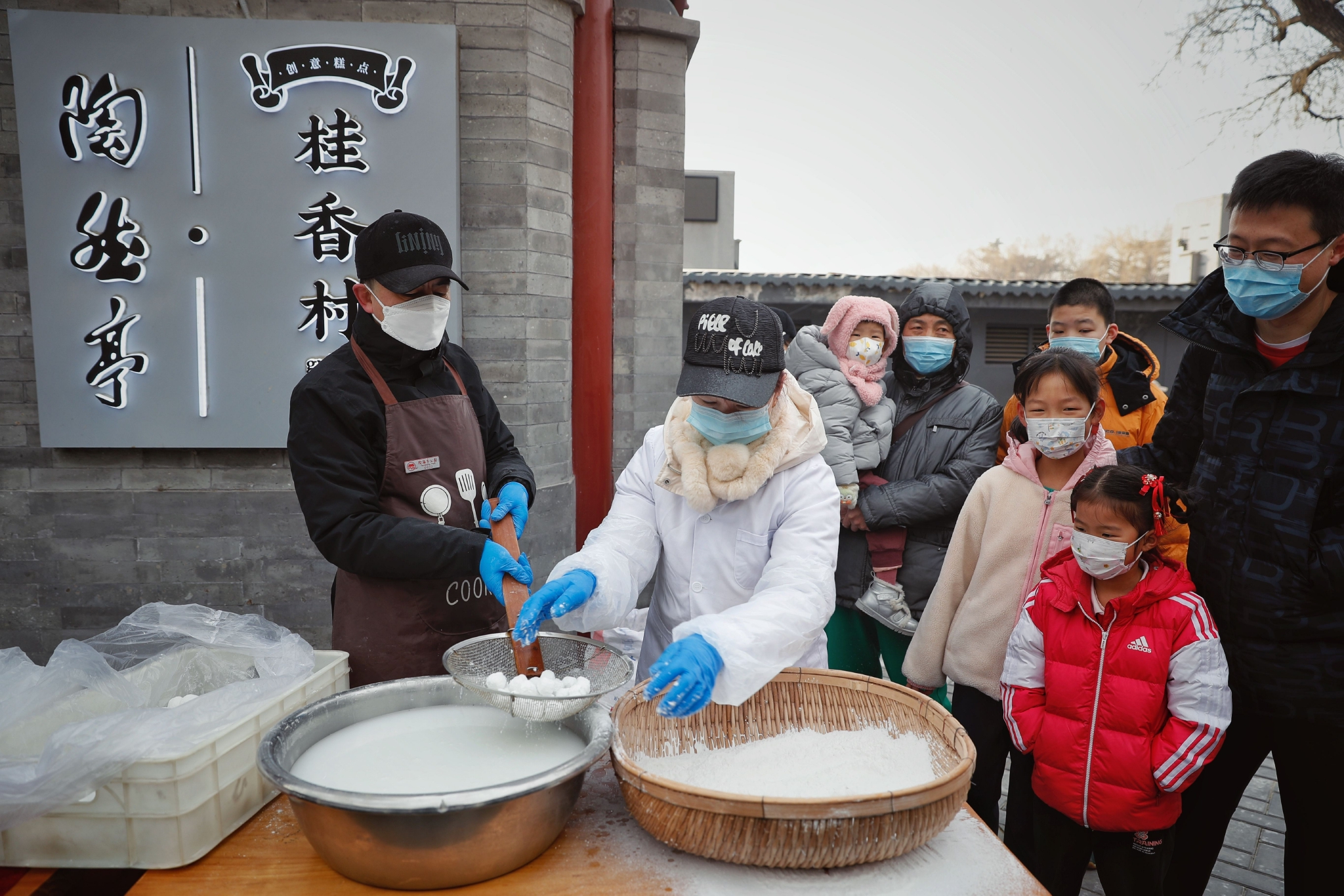 2023年2月5日，陶然亭公園，小朋友們好奇地看著工作人員現場演示搖元宵。  新京報記者 薛珺 攝