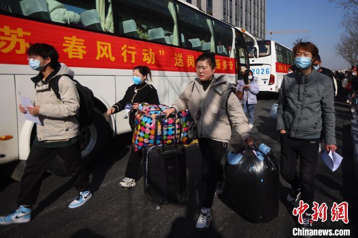 1月31日,求职者与企业签订就业协议后,与外地返岗人员一同乘坐专车直接奔赴一线工作岗位。 泱波 摄